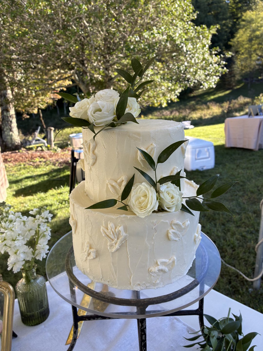 Custom white wedding cake styled with fresh flowers